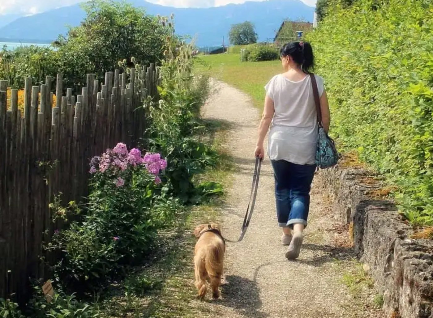 Pies na smyczy spacerujący ze swoją opiekunką